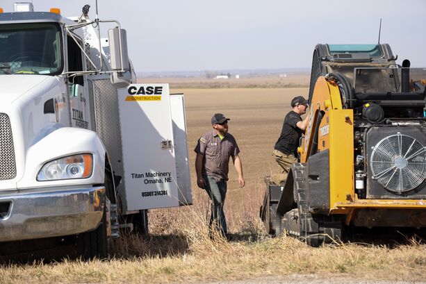 Construction technicians working on a Compact Track Loader with Truck