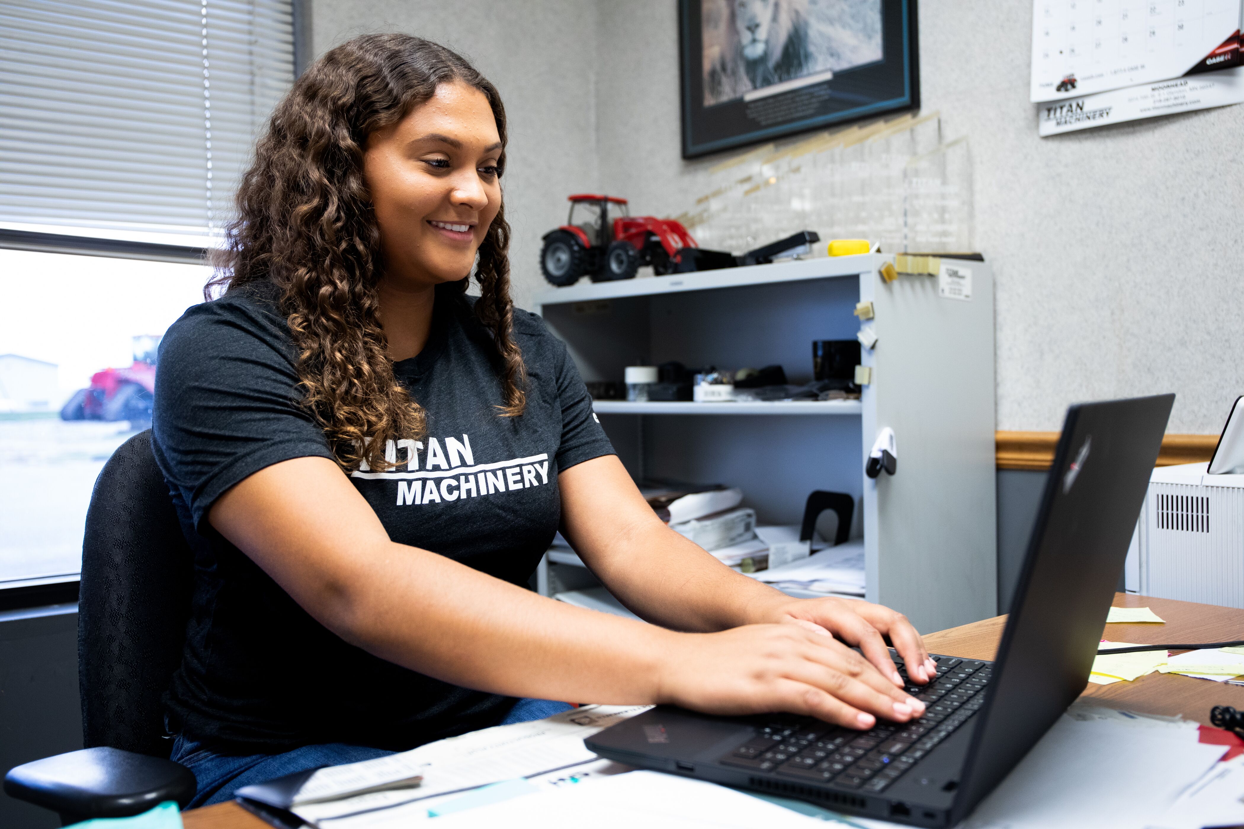 Female student at Case dealership on laptop