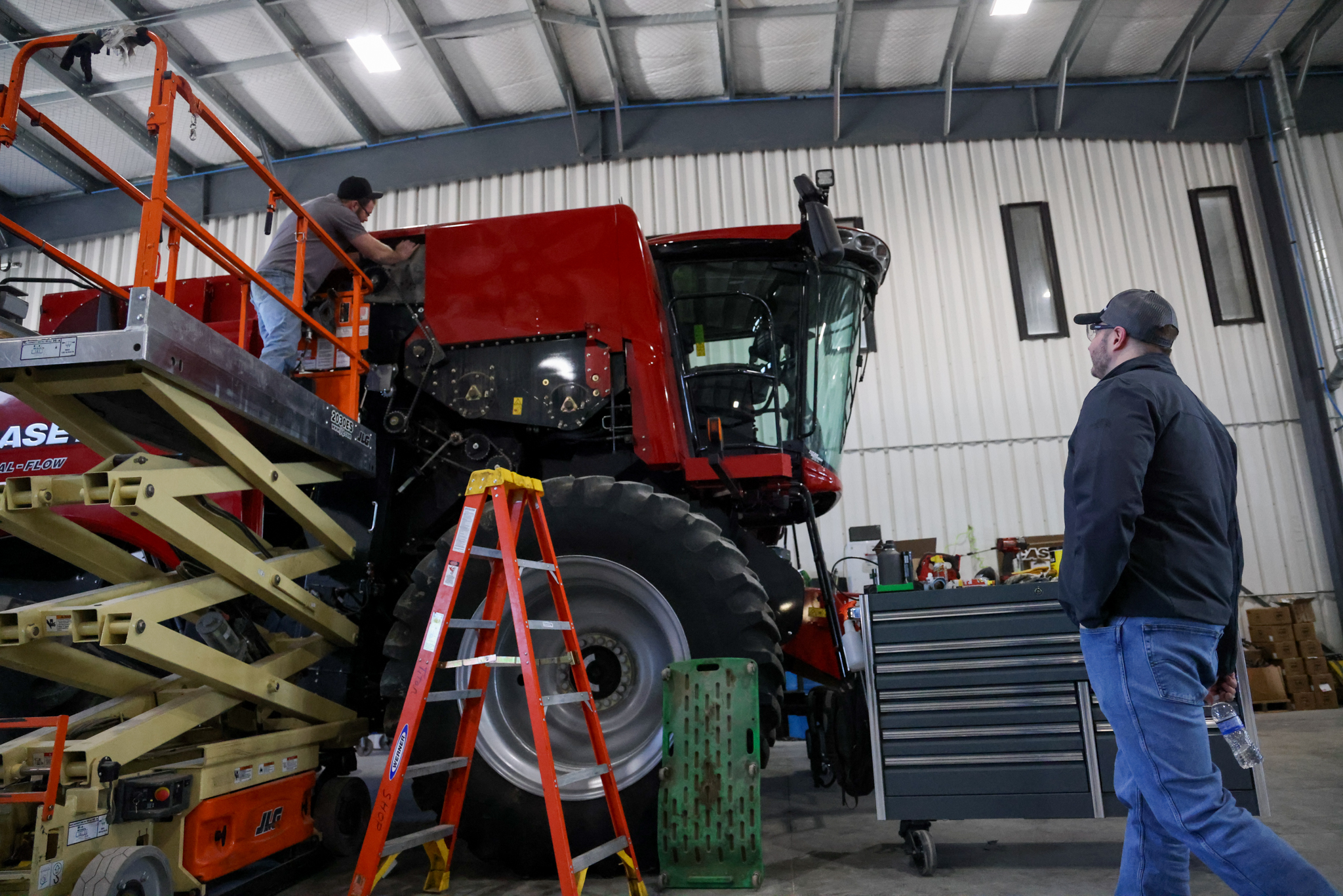Tech on combine Techs working on combine